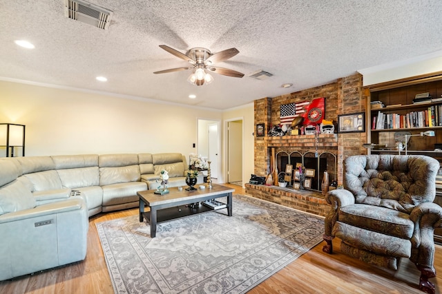 living room with a textured ceiling, ceiling fan, and light hardwood / wood-style flooring