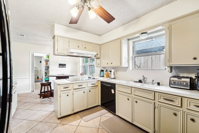 kitchen with cream cabinets, kitchen peninsula, black appliances, a textured ceiling, and sink