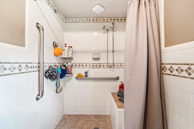 bathroom featuring tile walls and a shower with shower curtain