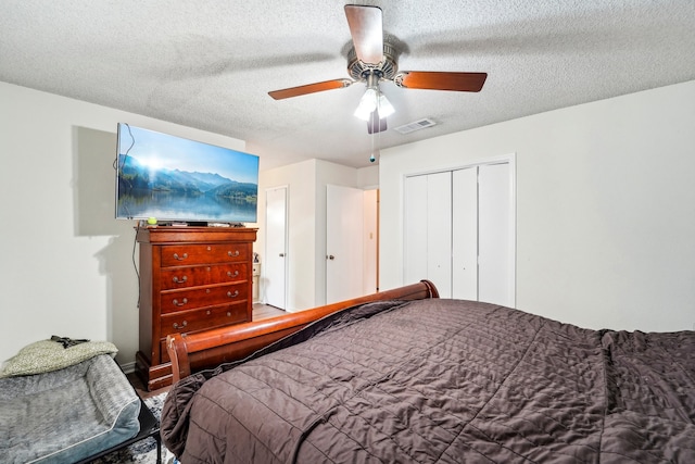 bedroom with a textured ceiling, ceiling fan, and a closet