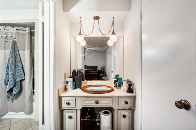 bathroom featuring tile patterned flooring, vanity, and a notable chandelier