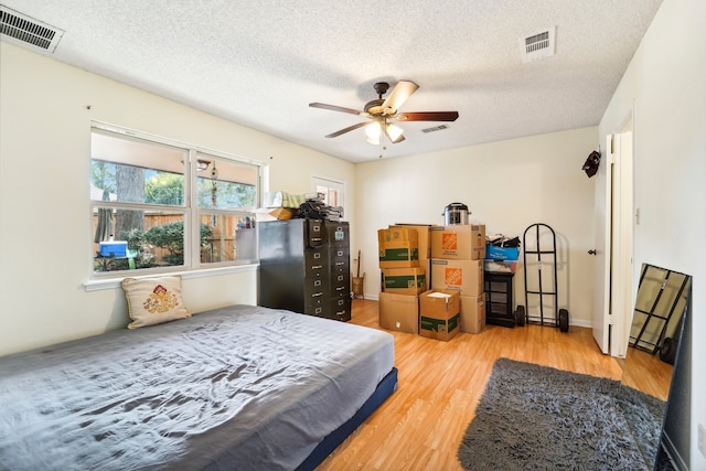 bedroom featuring ceiling fan, a textured ceiling, and wood-type flooring