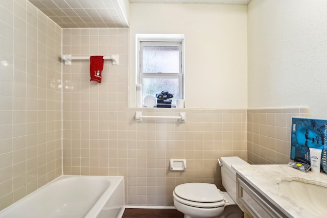 bathroom with tile walls, vanity, and toilet