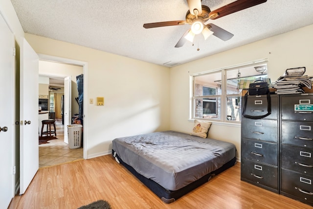 bedroom with a textured ceiling, hardwood / wood-style floors, ceiling fan, and pool table