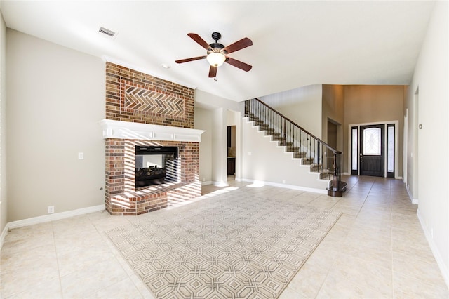 unfurnished living room featuring tile patterned floors, ceiling fan, a fireplace, and high vaulted ceiling