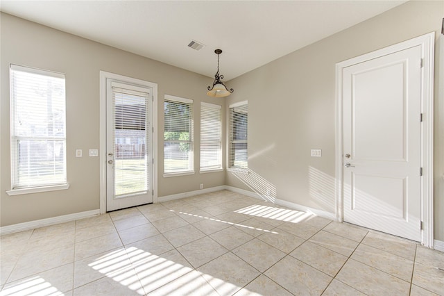 unfurnished dining area featuring light tile patterned flooring and a notable chandelier