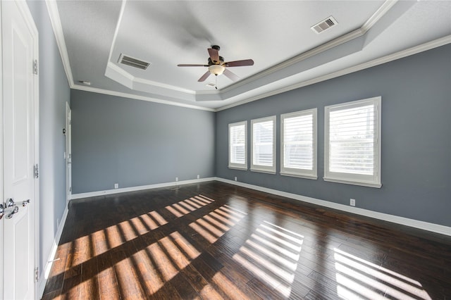 unfurnished room featuring a raised ceiling, crown molding, dark hardwood / wood-style flooring, and ceiling fan