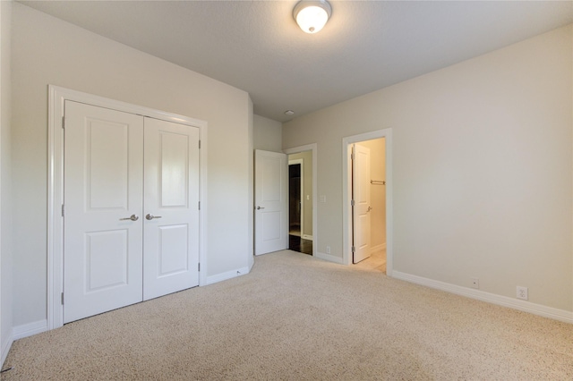 unfurnished bedroom with light carpet and a closet