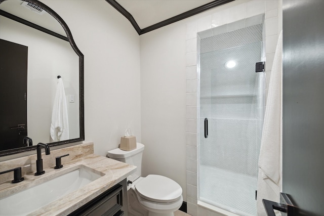 bathroom featuring toilet, vanity, crown molding, and a shower with door