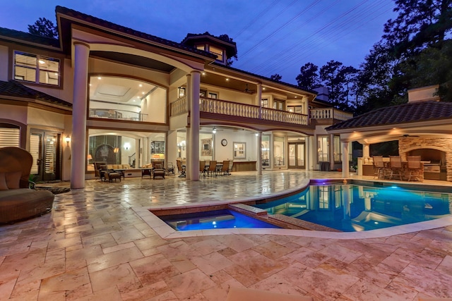 view of pool with an in ground hot tub, ceiling fan, an outdoor hangout area, an outdoor bar, and a patio area