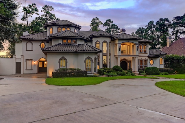 mediterranean / spanish-style house with a lawn