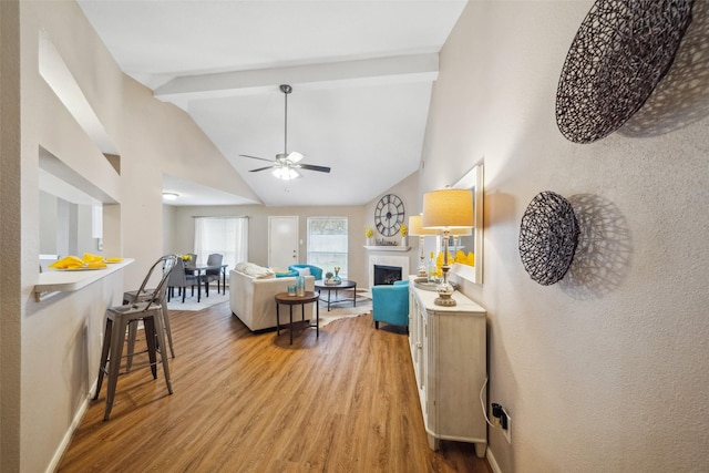 living room featuring ceiling fan, light hardwood / wood-style flooring, and lofted ceiling