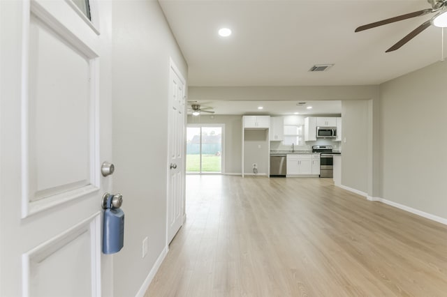 unfurnished living room featuring ceiling fan and light hardwood / wood-style flooring