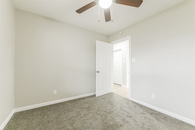 carpeted spare room with ceiling fan