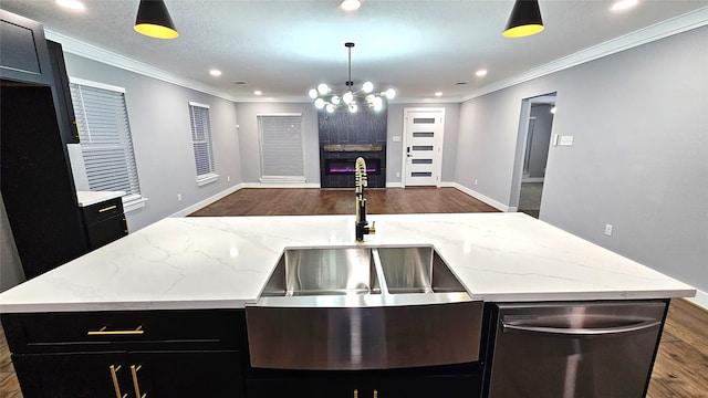 kitchen with dishwasher, sink, decorative light fixtures, and a kitchen island with sink