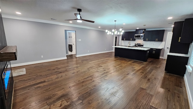 kitchen featuring stainless steel appliances, sink, an island with sink, dark hardwood / wood-style flooring, and decorative backsplash