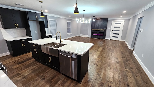 kitchen with tasteful backsplash, a center island with sink, decorative light fixtures, sink, and dishwasher