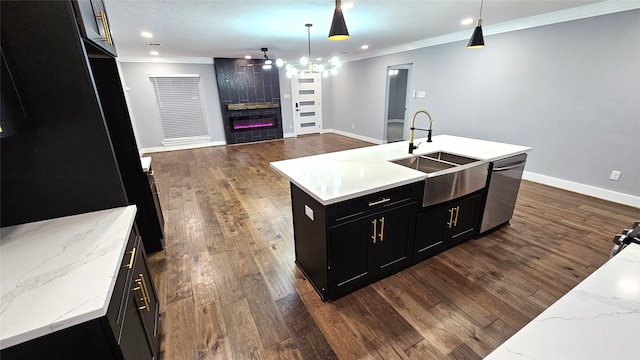 kitchen featuring crown molding, dark hardwood / wood-style floors, hanging light fixtures, an island with sink, and dishwasher