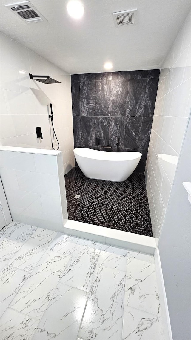 4526 Dixie Dr, Houston, TX 77021 - full bath featuring marble finish floors, a freestanding tub, tile walls, tiled shower, and recessed lighting