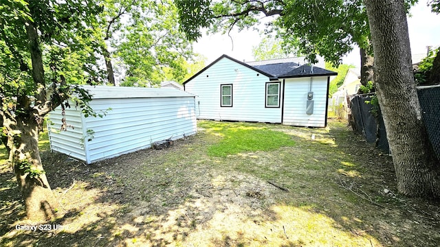 back of property featuring a storage unit