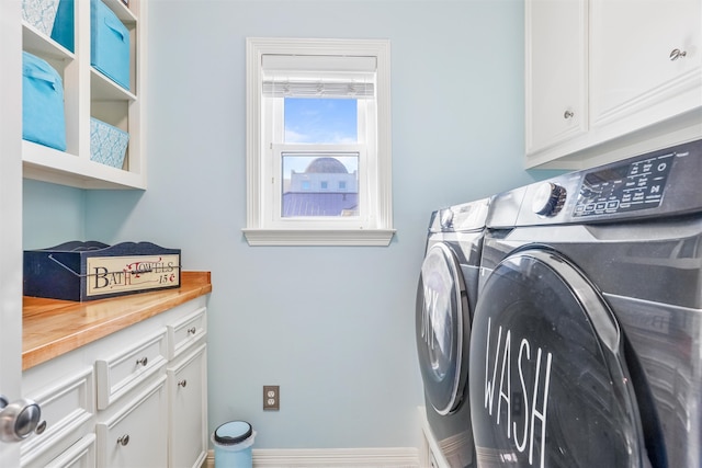 washroom with washer and clothes dryer and cabinets