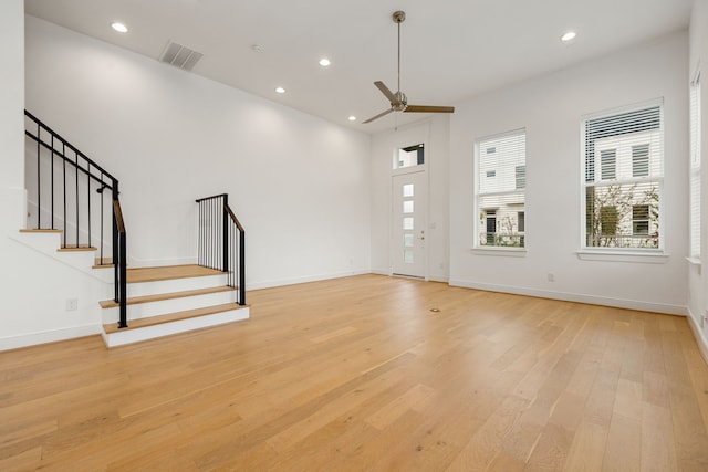 unfurnished living room with ceiling fan and light wood-type flooring