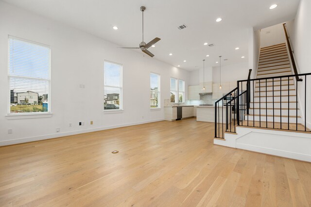 unfurnished living room with ceiling fan and light wood-type flooring