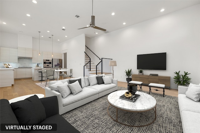 living room featuring light wood-type flooring and ceiling fan