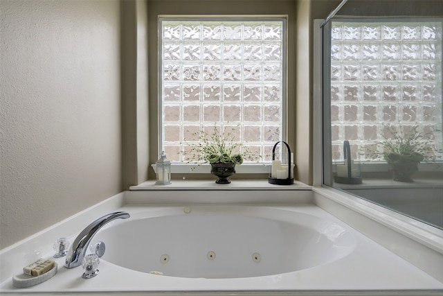 bathroom with a tub to relax in and plenty of natural light