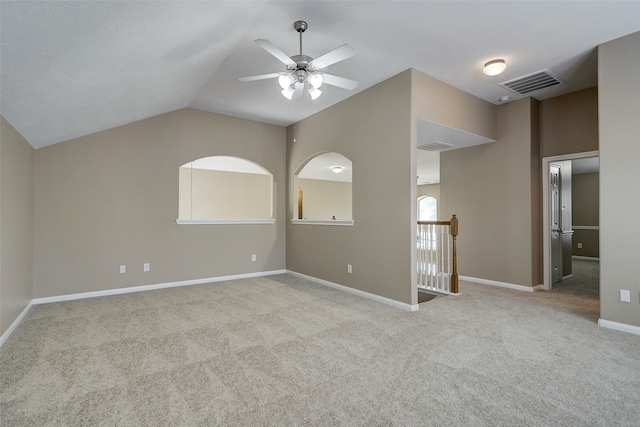 carpeted empty room featuring lofted ceiling and ceiling fan