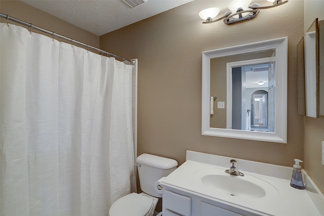 bathroom featuring vanity, a textured ceiling, and toilet