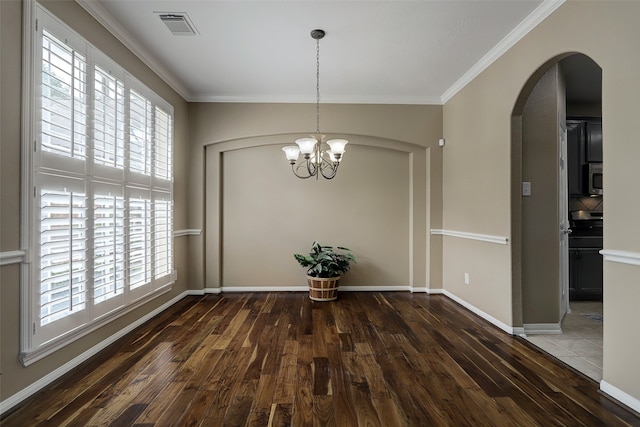 unfurnished dining area featuring dark wood-type flooring, a notable chandelier, and crown molding