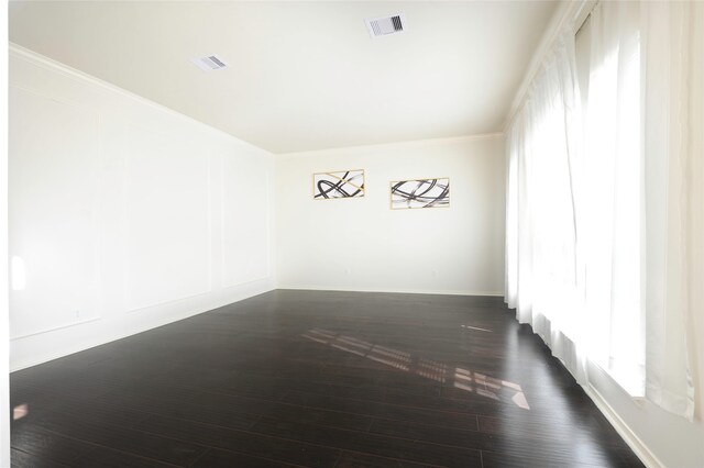 spare room with dark wood-type flooring and ornamental molding