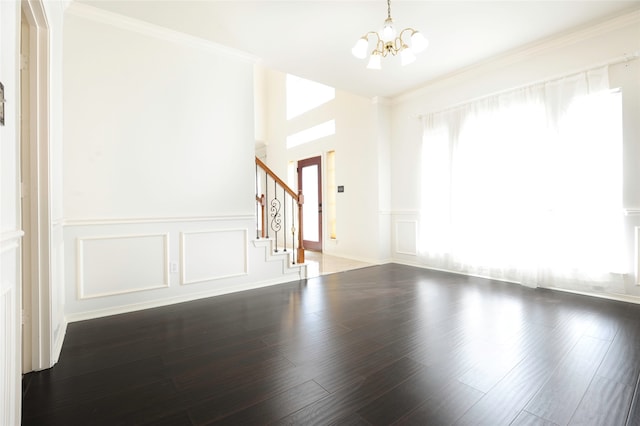 spare room featuring a chandelier, dark hardwood / wood-style floors, and crown molding