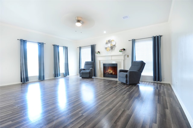 living room with dark hardwood / wood-style flooring, ceiling fan, and crown molding