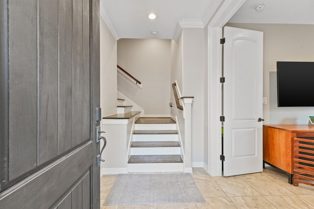 stairs with tile patterned floors and crown molding