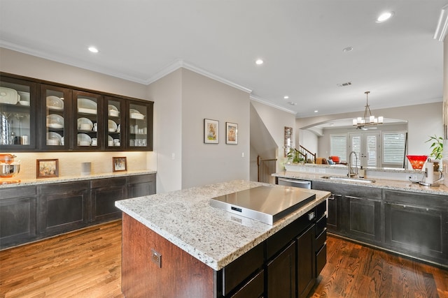 kitchen featuring hardwood / wood-style flooring, decorative light fixtures, sink, and a center island