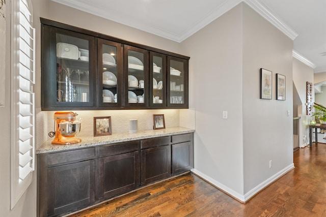 bar featuring dark hardwood / wood-style floors, crown molding, and backsplash