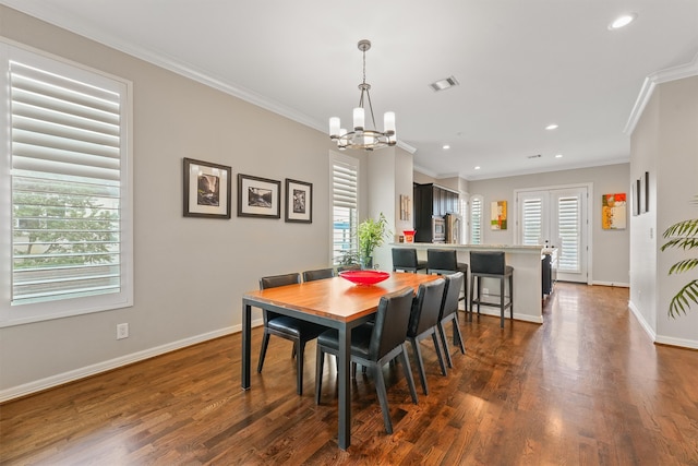 dining area with dark wood-type flooring, a chandelier, a healthy amount of sunlight, and crown molding