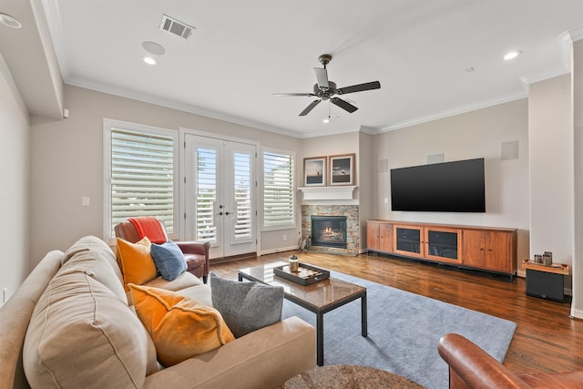 living room with ornamental molding, a fireplace, dark wood-type flooring, and ceiling fan