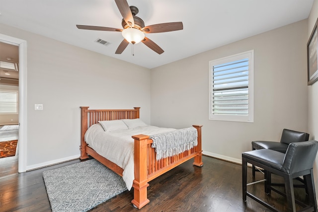 bedroom featuring dark wood-type flooring, multiple windows, and ceiling fan