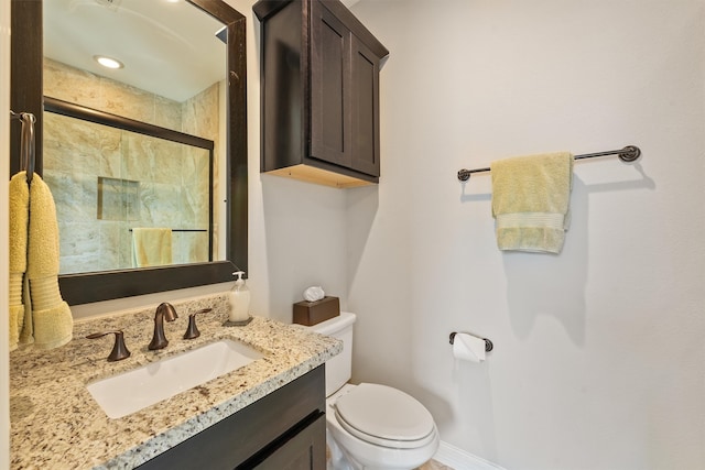 bathroom with vanity, toilet, and a shower with door