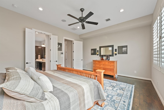 bedroom with dark wood-type flooring, ceiling fan, and connected bathroom