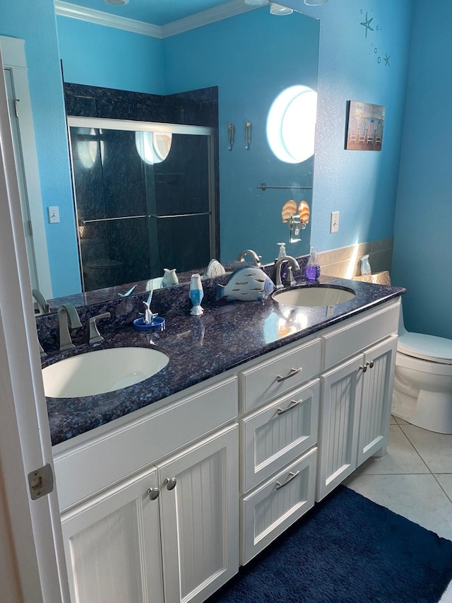 bathroom with tile patterned floors, toilet, a shower with door, ornamental molding, and vanity