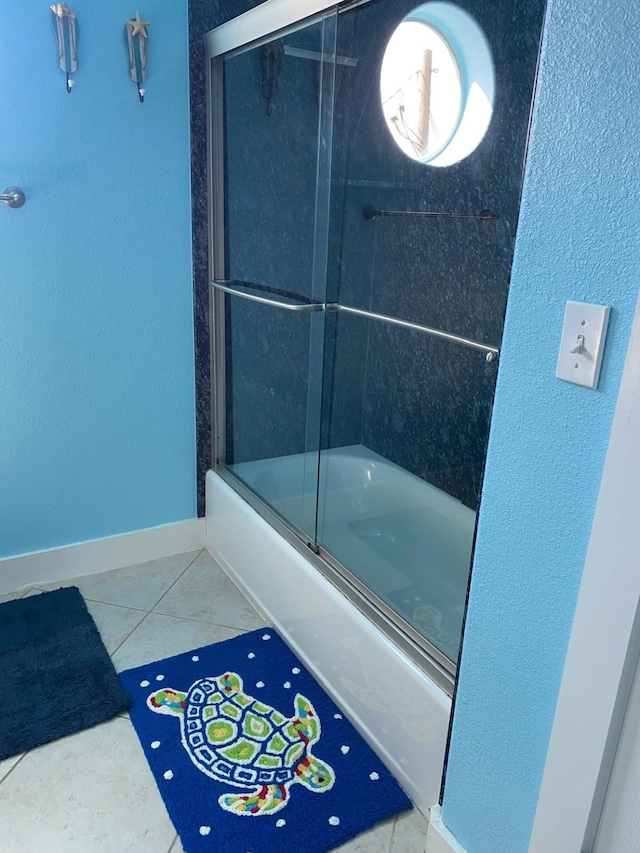 bathroom featuring enclosed tub / shower combo and tile patterned floors