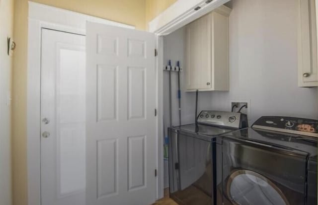 washroom with cabinets and washing machine and dryer