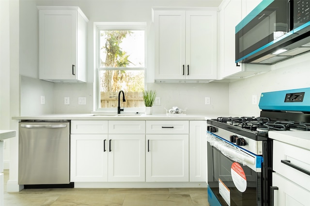 kitchen with white cabinets, gas range oven, stainless steel dishwasher, and sink