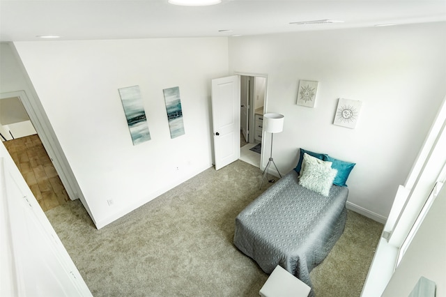 bedroom featuring ensuite bathroom, light colored carpet, and high vaulted ceiling