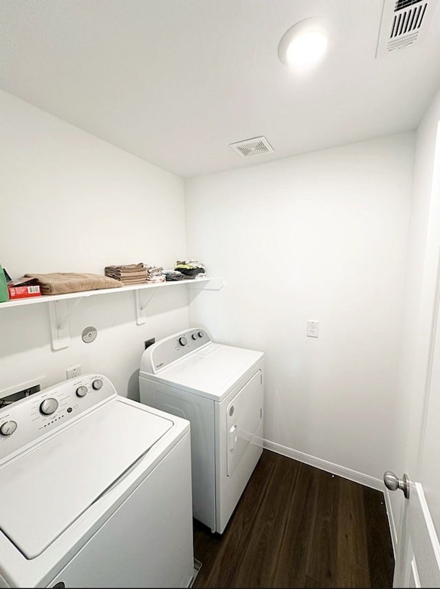 laundry room with washer and dryer and dark hardwood / wood-style floors