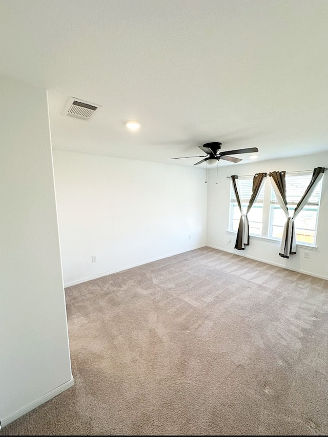 carpeted empty room featuring ceiling fan